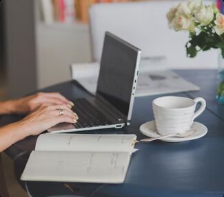 woman with fingers on laptop keyboard