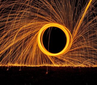 graphic image of bright orange circle with numerous light strands around it